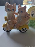 Pair of cat shakers on yellow scooter