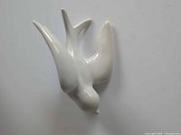 front view of glossy white ceramic swallow figurine