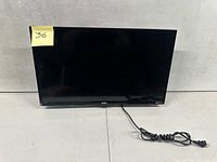 Front view of TV powered off showing screen and attached power cord