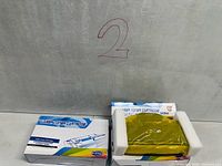 Two Inkfirst laser toner cartridge boxes, one partially opened showing cartridge wrapped in yellow film