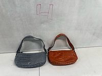 Front view of both purses showing color and crocodile texture