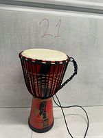 Full view of drum showing painted body, rope lacing, drumhead