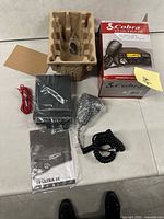 All contents laid out: radio unit, microphone, power lead, manual, insert and box