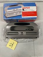 Boxed Staples heavy-duty 3-hole punch and punch itself