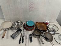 Entire assortment of cookware, utensils, dinnerware and tin displayed on table