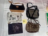 Overview of the five handbags and clutch arranged on table