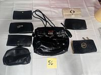 All eight handbags and wallets arranged on table