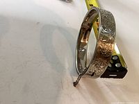 Full view of engraved sterling bangle showing clasp, hinge and safety chain