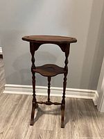 Front view of wooden two-tier plant stand showing shelves and legs