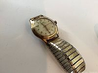 Front view of gold-plated automatic wristwatch showing dial and bracelet