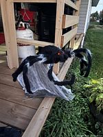 Full view of spider on deck, showing body, legs, gauze skirt, red LED eyes