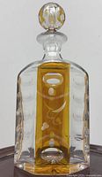 Full view of decanter front showing amber overlay, etched design, stopper