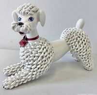Full side view of white ceramic spaghetti poodle statue