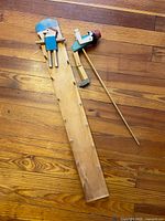 All components laid out: game board, two figures, mallet head, dowel rod