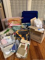 Group shot of all craft supplies including glue gun, felt sheets, raffia, packing materials