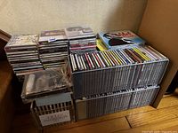 Multiple stacks and shelf row of CDs showing quantity and storage