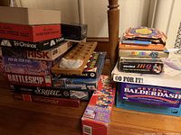 Stack of boxed games showing titles and wooden Mancala board