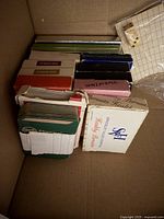 Multiple decks of playing cards stacked in cardboard box