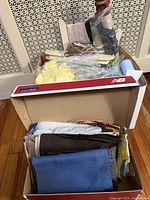 Two boxes: front box of fabric pieces; back box of bagged trims