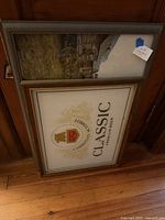 Both framed pieces leaning against wood wall