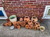 Full assortment of pots aligned against brick wall