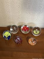 All six paperweights grouped on tabletop