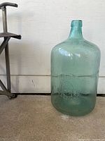 Full view of aqua glass jug standing upright