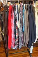 Clothing rack with shirts, jackets, trench coat visible