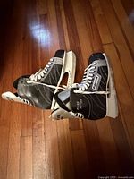 Pair of Bauer men’s ice skates lying on floor