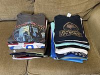 Two stacks of folded men’s T-shirts on sofa