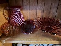 Group shot of all four red glass pieces on shelf