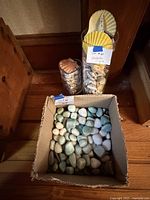 Box of pastel stones; two glass vases with seashells
