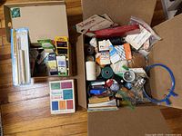 Two boxes filled with assorted sewing notions, thread, bias tape, embroidery hoop and more