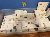 Bin filled with assorted stamped envelopes and postal cards