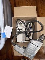 Corded drill and surge protector in cardboard box