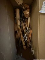 Box containing stacked wooden clamp hangers
