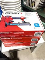 Stack of three boxed Arrow PT50 pneumatic staplers