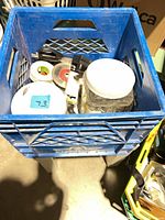 Milk crate with assorted hardware and tools