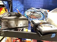Eliminator charger, portable compressor, booster cables on shelf
