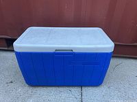 Front view of blue Coleman cooler with closed white lid