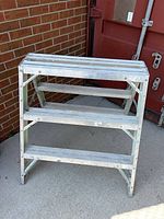 Front view of aluminum step ladder showing three steps and overall structure