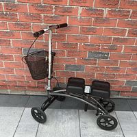 Left side view of knee scooter showing basket, frame, wheels