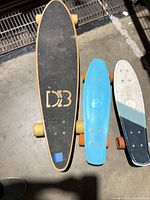 Top view of DB Longboards longboard, blue cruiser and white-teal cruiser