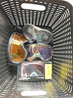 Basket containing three unboxed goggles and one boxed pair