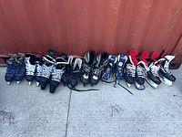 Eight pairs of skates lined up side by side showing overall quantity and condition