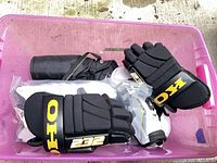 Pink tote containing KOHO gloves, black protective gear, shin guards