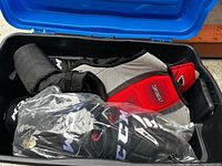 Contents of tote showing pants, gloves in bag, grey/red pad