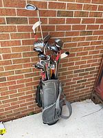 Full view of bag with clubs against brick wall