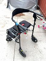 Side angle of folded Nexus rollator showing frame, wheels, seat, brakes