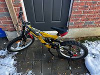 Left side view of yellow Supercycle Wicked mountain bike showing frame, wheels and kickstand